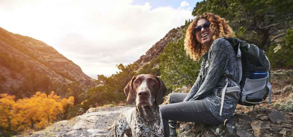 Free checking girl sitting on trail with her dog.